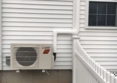 A white house featuring a side-mounted air conditioner, showcasing a typical residential exterior.